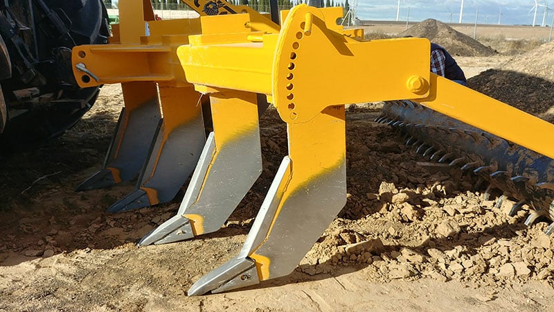 Image d'une machine de sous-solage utilisée dans la préparation du sol pour briser et désintégrer les couches de calcaire les plus superficielles du sol.