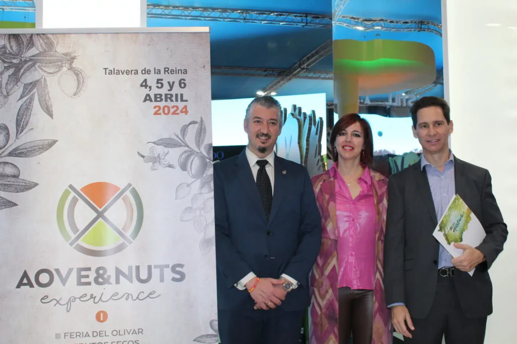 Gerardo Sánchez, Cristina MArtin y Javier Moreno posan junto al cartel de la feria AOVE & NUTS Experience 2024